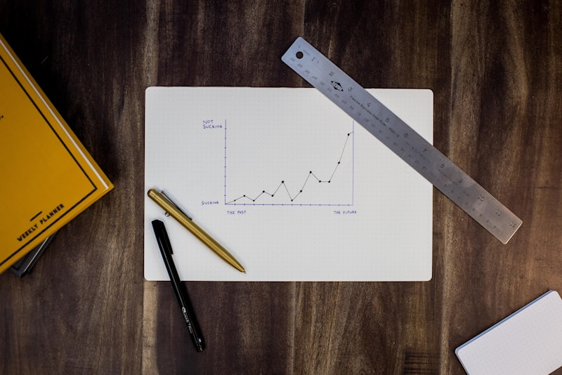 A calendar and a pen on a plain wooden desk